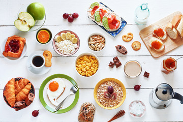 Breakfast menu food frame with a copy space. Eggs, croissants, oatmeal with banana, cereal, danish...
