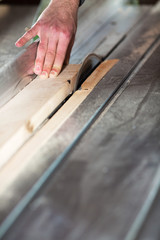 Plank of wood being cut with circular saw in workshop.