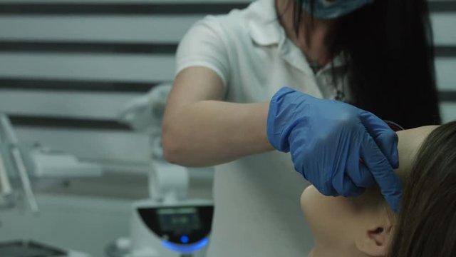 Dentist wearing the dental protective glasses on female patient.