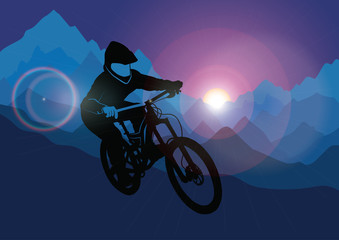 Fototapeta na wymiar Silhouette of a racer descending on a bicycle on a mountainside against the background of the evening sun