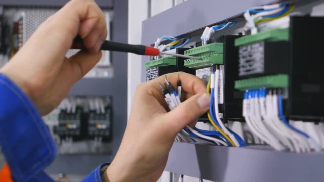 Electrician connecting the wires with screwdriver.