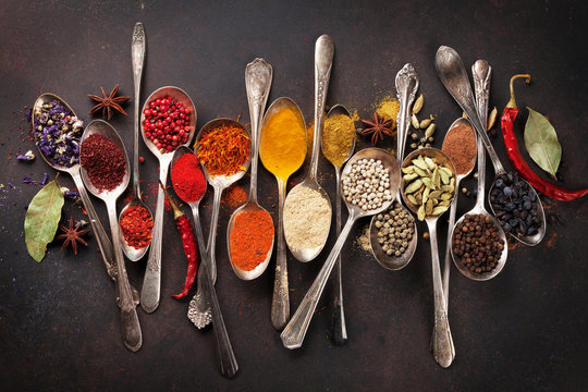 Various spices spoons on stone table