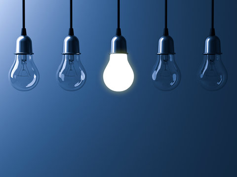 One hanging light bulb glowing different and standing out from unlit incandescent bulbs with reflection on dark blue background , leadership and different business creative idea concept. 3D rendering.