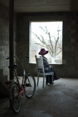 Obraz premium Old lady sit in concrete building