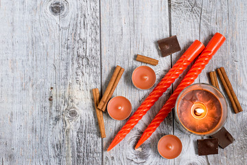  Home coziness. Decorative aromatic candles of various shapes, cinnamon sticks and pieces of dark...