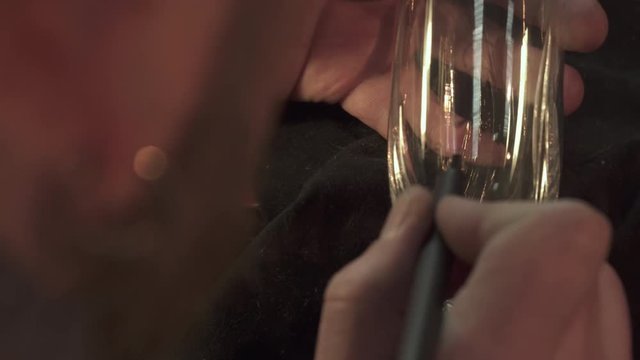 Young male engraver putting the pattern on the glass. Close up of bearded caucasian man moving the marker on glass surface. Brunette guy making blank for engraving