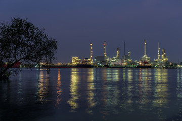 Obraz premium Refinery tower in petrochemical industrial plant with river