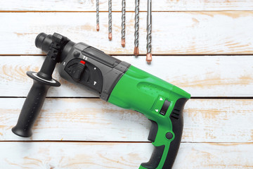 Electric hammer drill lies on a wooden table