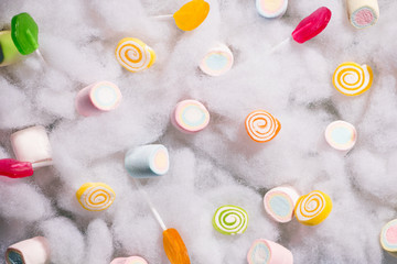 Top view of pastel colored marshmallow on a cotton background. Minimalism style.