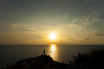 Fototapeta premium Silhouette man playing with the drone,beautiful sunset sky and sea.