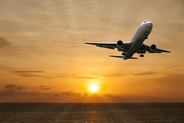 Fototapeta na wymiar aircraft flying with scenic view of beautiful sunset and sea over the andaman.
