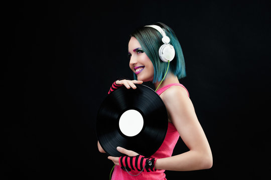 Portrait d'une jeune femme souriante, pr&eacute;sentant un disque vinyle dans ses mains