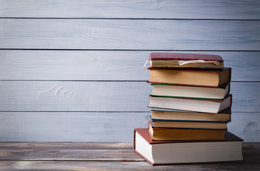 Old books on a blue wooden background with copy space