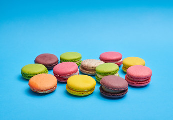 Close-up shot of a brightly colored macaroons lying on a blue background