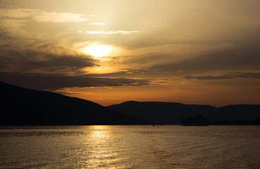 Sunset on the sea, view to sea in the evening. The ships and the mountains
