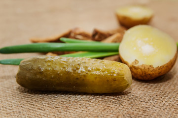 Boiled potatoes in a peel with salt and a green onion on a close-up table. Healthy food.