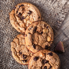 Chocolate cookies on dark  napkin on wooden table. Closeup of a group of assorted cookies..