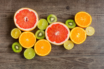 Slices fresh fruits on a brown board.