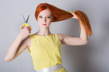 woman with long hair holds scissors