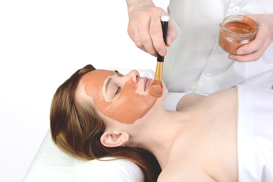  Young woman with nutrient facial mask in beauty salon