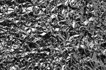 Silver foil background with shiny crumpled surface for texture background
