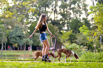 girl skating with dogs at the park