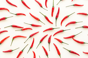 A lot of red hot chili peppers on a white background. a concept hot spice for food. top view, flat lay. Concept red food, many red peppers as background.
