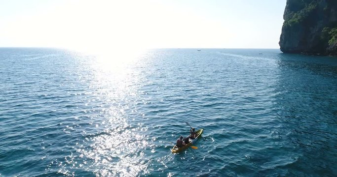 Aerial shot of couple kayaking in turquoise sea during summer day. Travel tropical island holiday concept