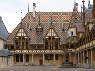 Fototapeta na wymiar Bourgogne - Côte d'Or - Hospices de Beaune - Hôtel-Dieu sous un ciel nuageux