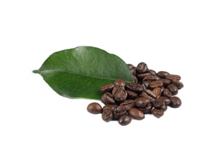 Pile of coffee grains with green leaf over white isolated background.