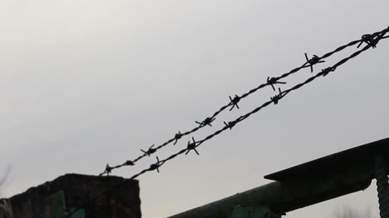 barbed wire fence gate prison exterior on heaven background - Powered by Adobe