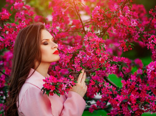 Fototapeta premium a young girl in the spring near flowering trees , a touch of spring , the fragrance of flowers