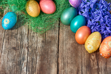 Easter eggs in nest on old wooden background with blue hyacinths flower