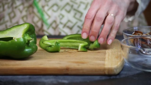 Chopping and slicing green peppers for a home made pizza.