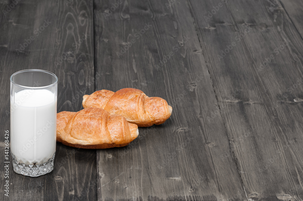 Poster glass of milk with pair of croissants on a old grey rustic wooden background with copy space for you