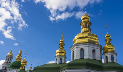 Fototapeta na wymiar Domes of Kiev Pechersk Lavra against the background of a cloudy sky