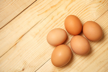 brown nicely lit eggs located in groups on wooden background