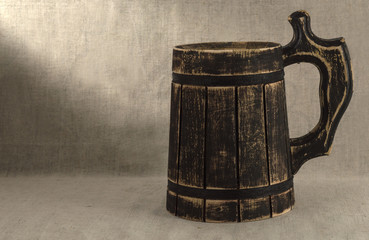 wooden beer mug on a linen background.