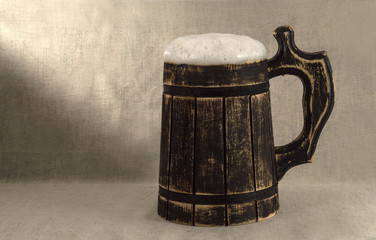 wooden beer mug on a linen background.