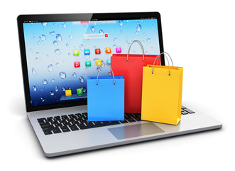 Laptop with group of color paper shopping bags
