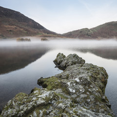 Fototapeta premium Stunning Winter foggy sunrise on Crummock Water in Lake District England