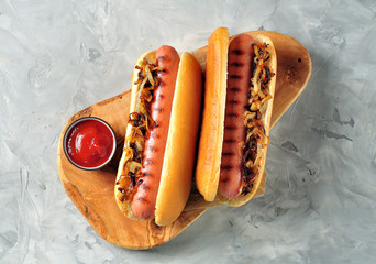 Two Hot dogs with crispy onion and ketchup.