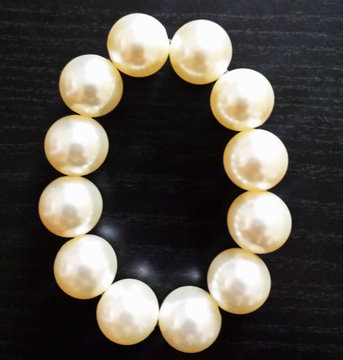 Beads from pearls. Pearl necklace. White pearls on a dark background