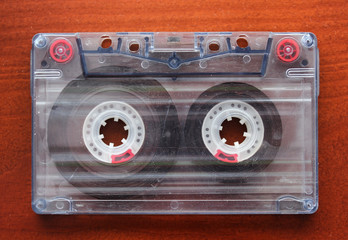 Old audio cassette close-up on a wooden brown background