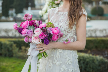 Bride with beautiful wedding bouquet. Pink rose and other flowers.