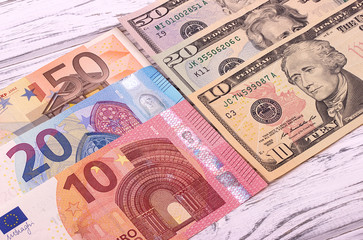 Money background american dollars and euro different denominationson old white wooden plank.