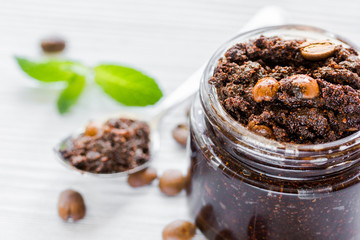 Homemade cosmetics with coffee scrub on white desk background
