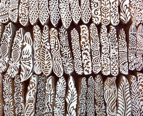 Leaves, flowers, patterns on wooden surface of mold blocks for traditional printing textile. Background from India