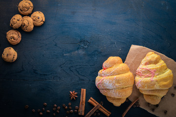 Croissant with yogurt. Pastry dough. On a black wooden background. Free space for text . Top view,