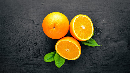 Fresh citrus fruits. Orange. On a black background Wooden. Top view.